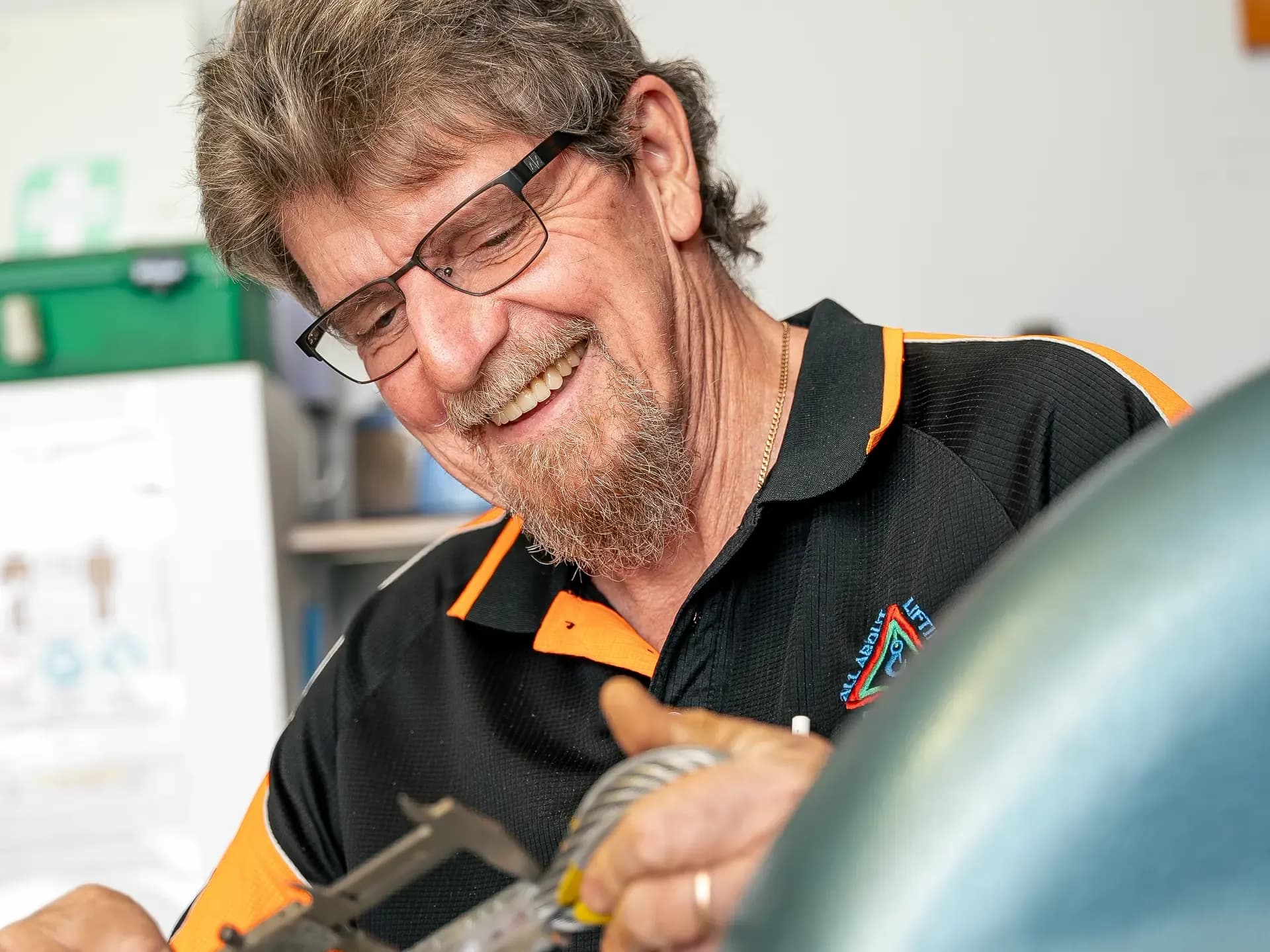 Technician measuring wire rope diameter with calipers during an inspection